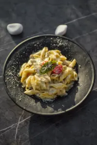 Pâtes à la crème dans une assiette noire