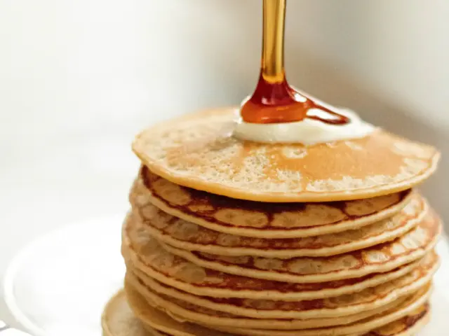 Pile de crêpes épaisses nappées de miel