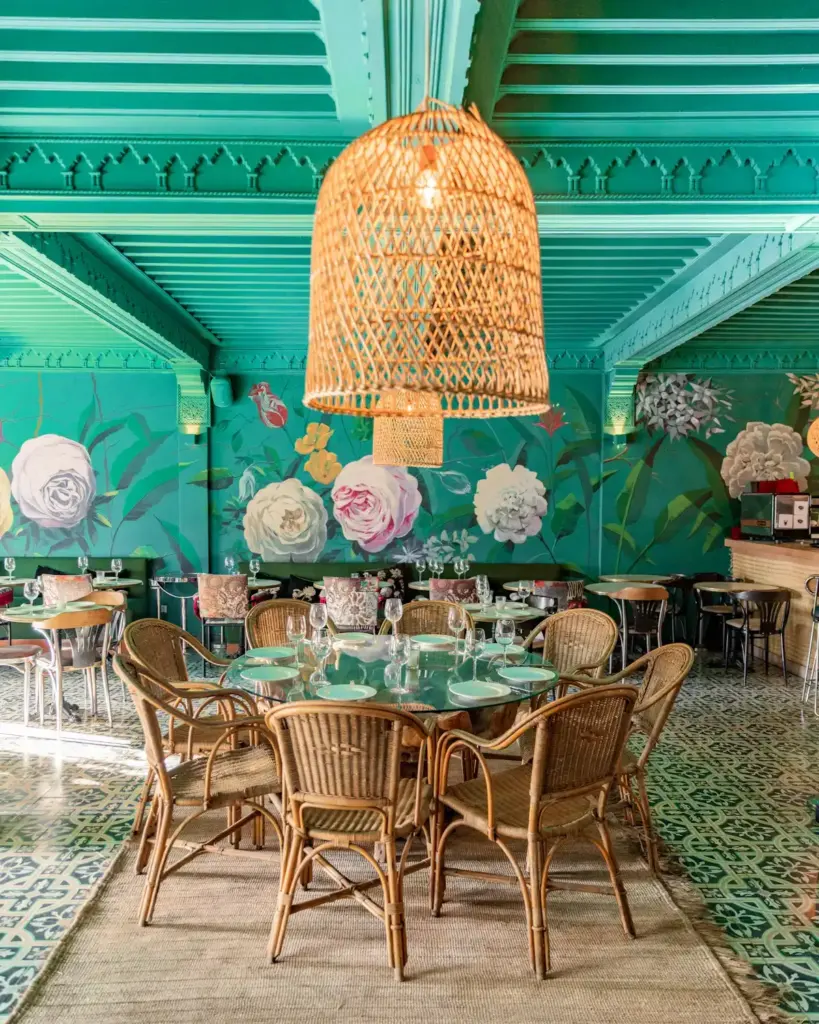 Salle de restaurant aux tons turquoise et suspensions en osier