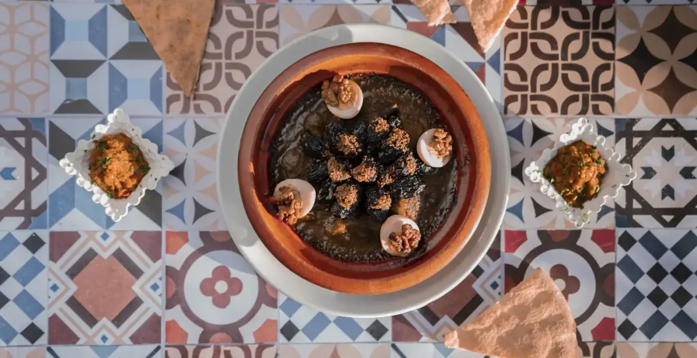 Tajine servi sur une nappe aux motifs zellige