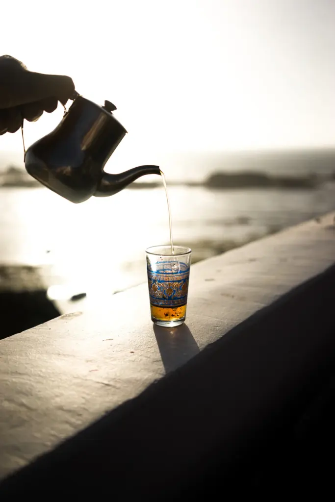 Thé versé dans un verre face à l'océan
